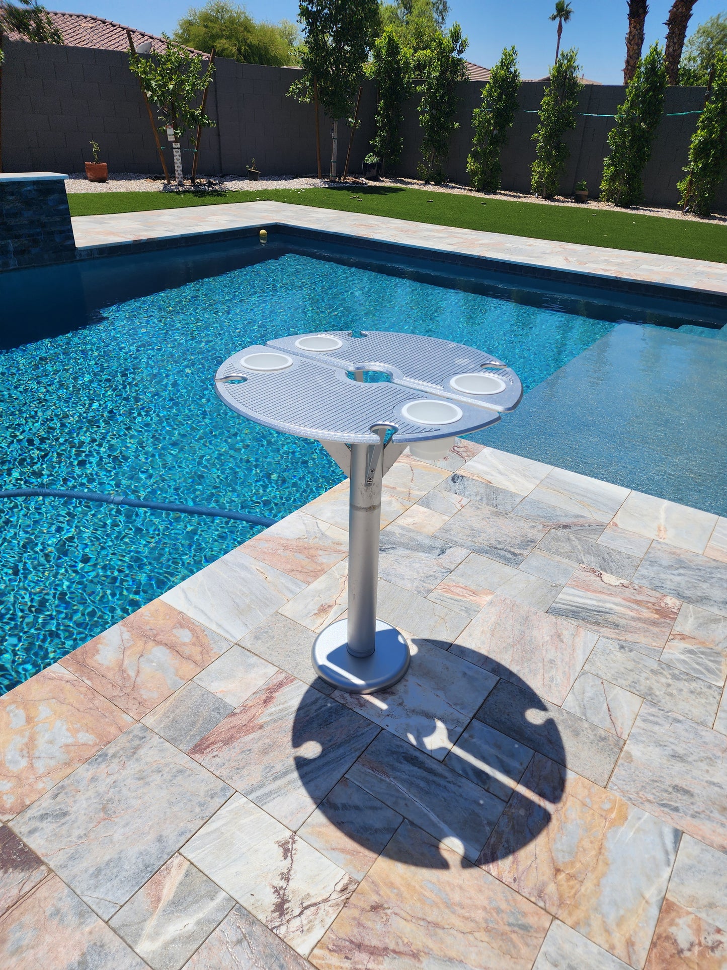 BAJAMATE 24" luxury aluminum poolside table with deck sleeve adapter, installed on patio or pool deck for umbrellas, drinks, and entertaining, premium outdoor living upgrade.