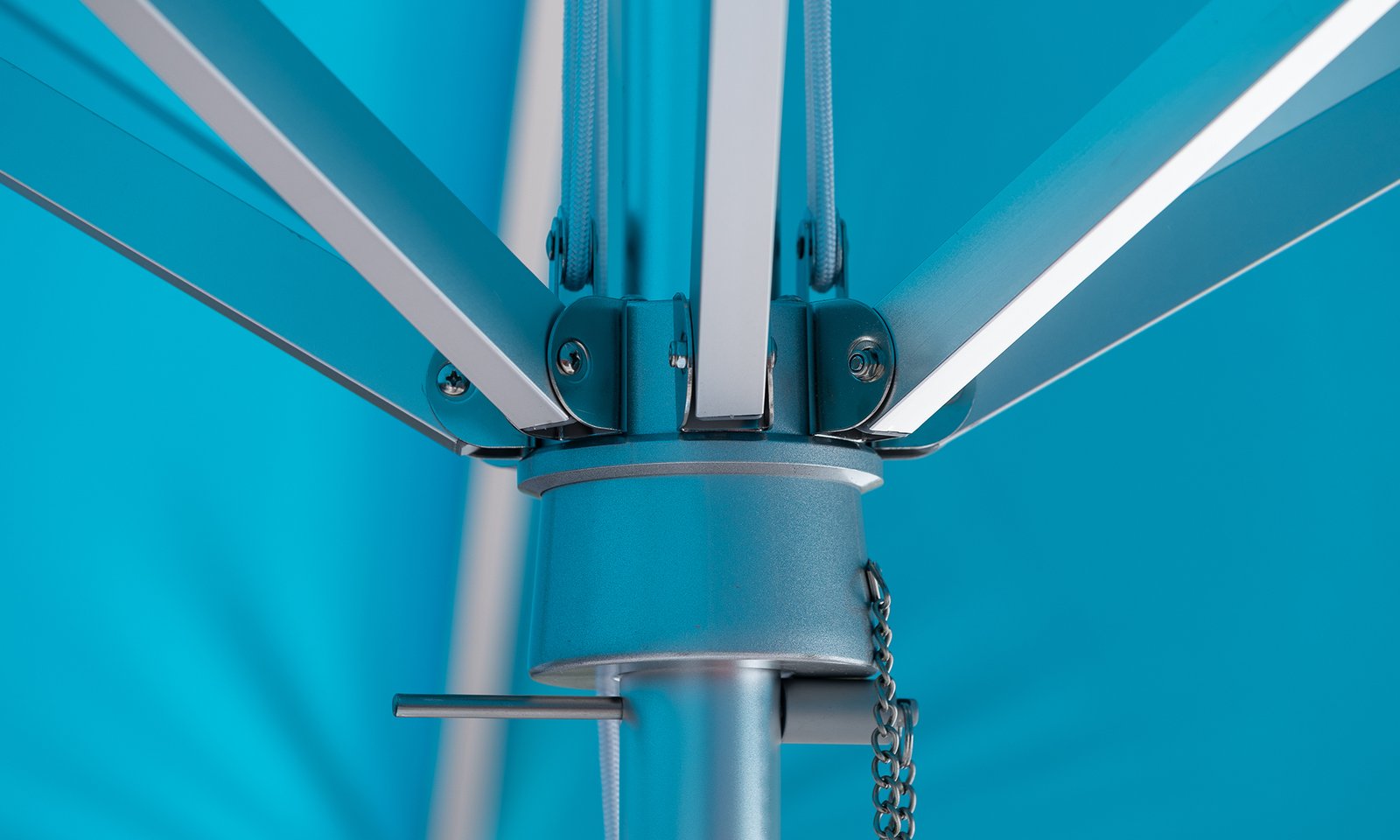 Close-up of BAJAMATE umbrella hub showing heavy-duty aluminum ribs bolted into a reinforced central housing on a 2-inch pole