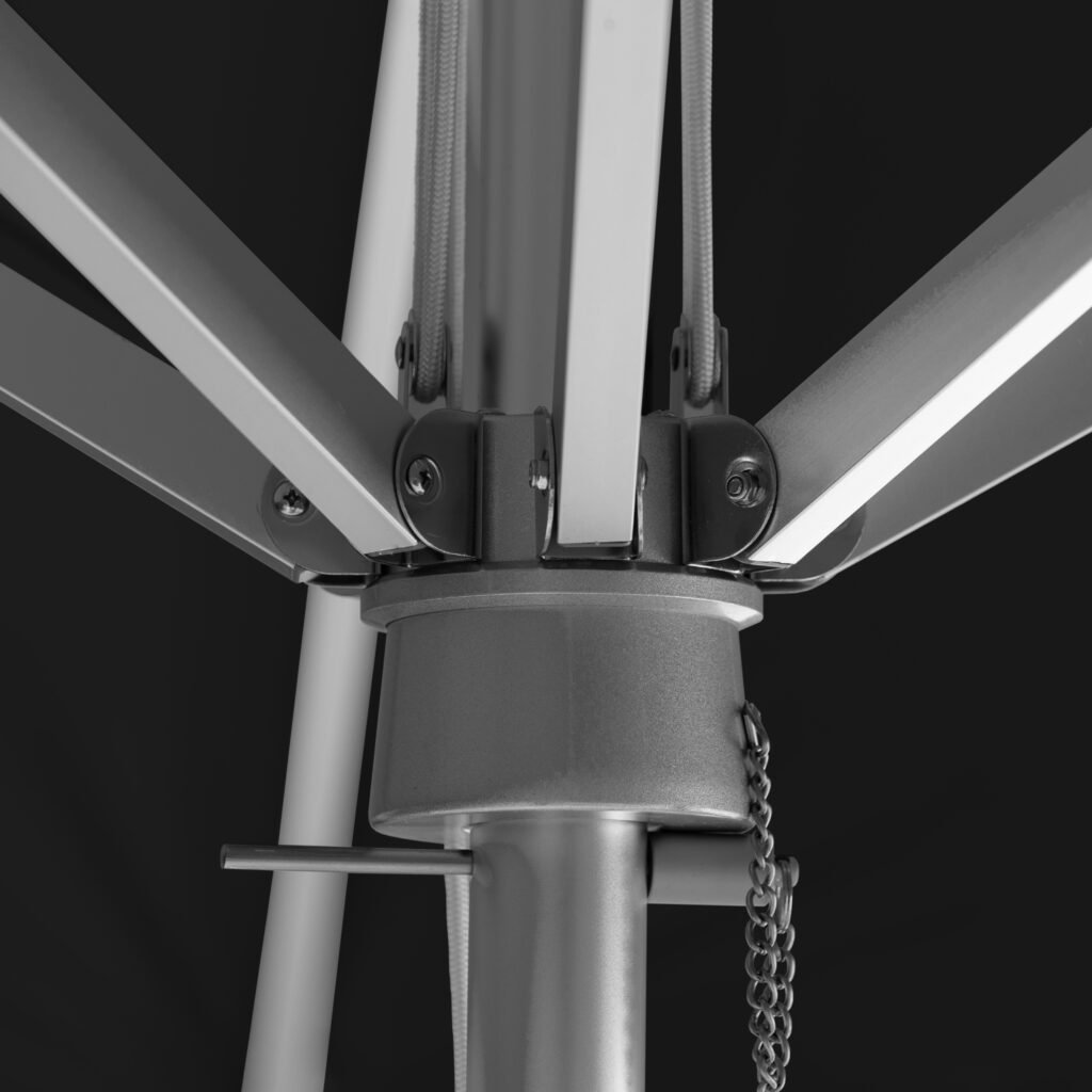 Close-up of BAJAMATE umbrella hub showing heavy-duty aluminum ribs bolted into a reinforced central housing on a 2-inch pole