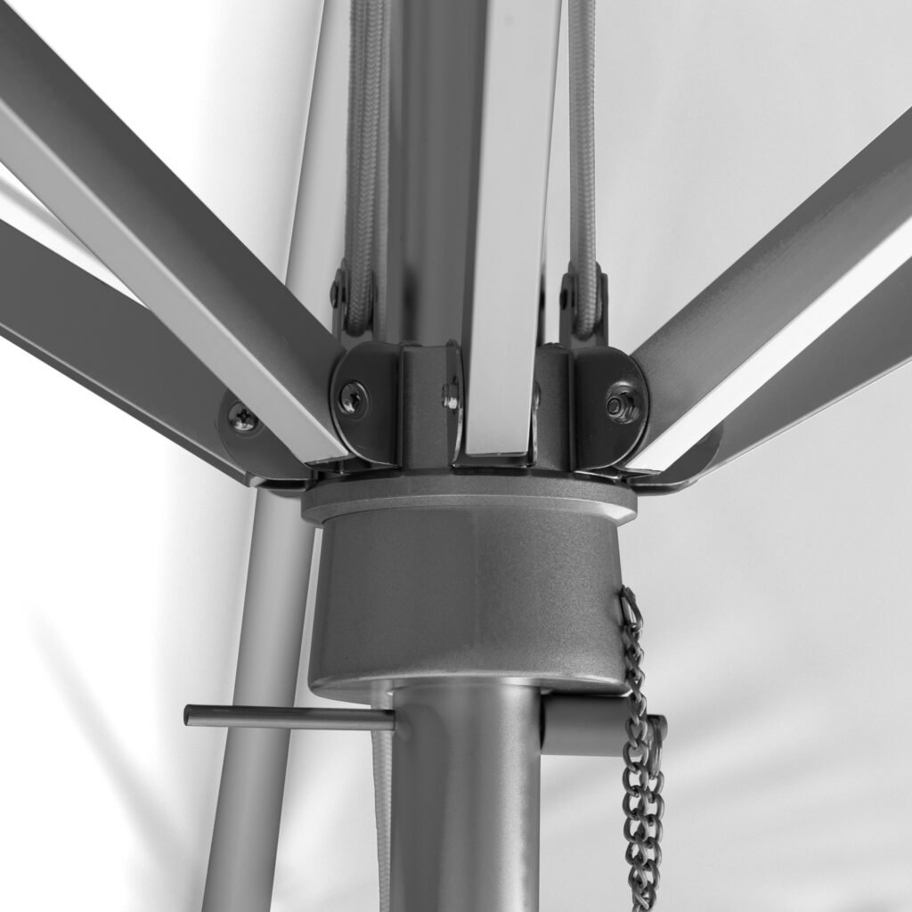 Close-up of BAJAMATE umbrella hub showing heavy-duty aluminum ribs bolted into a reinforced central housing on a 2-inch pole